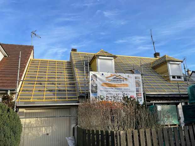 Deux lucarnes sur un toit en rénovation.