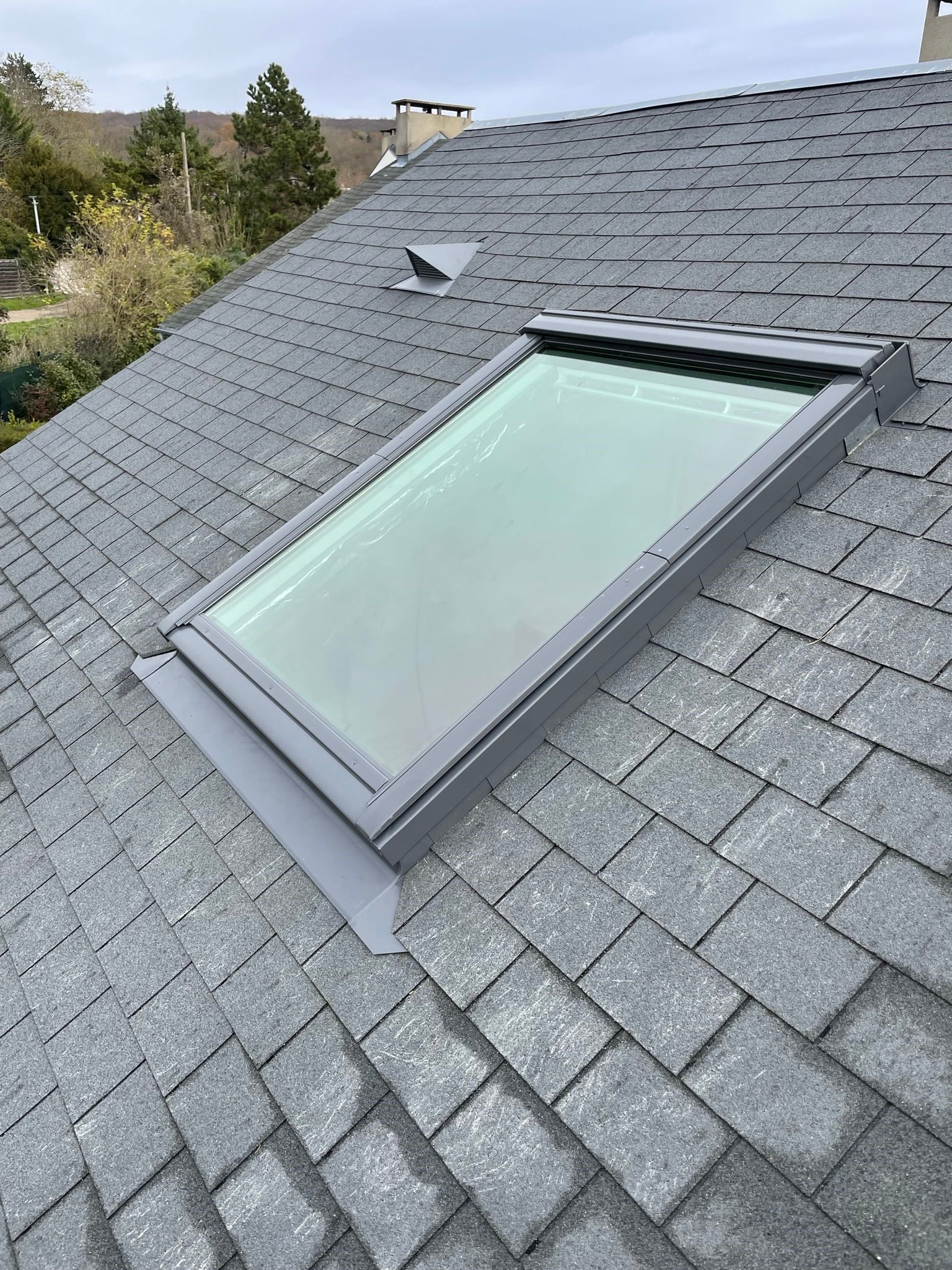 Toiture en ardoise avec une fenêtre de toit.