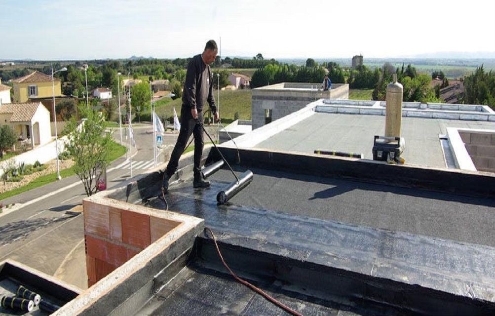 Artisan travaillant sur un toit-terrasse avec un rouleau
