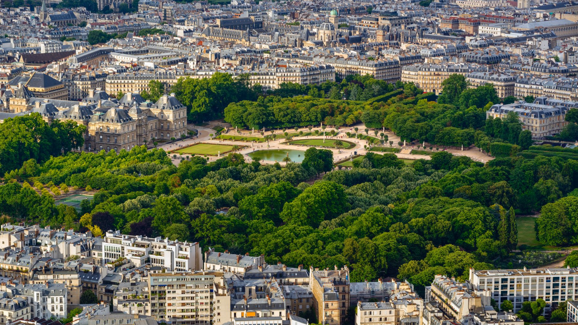 Vue aérienne de Paris avec l'Arc de Triomphe et le parc arboré qui l'entoure, au milieu des immeubles de la ville