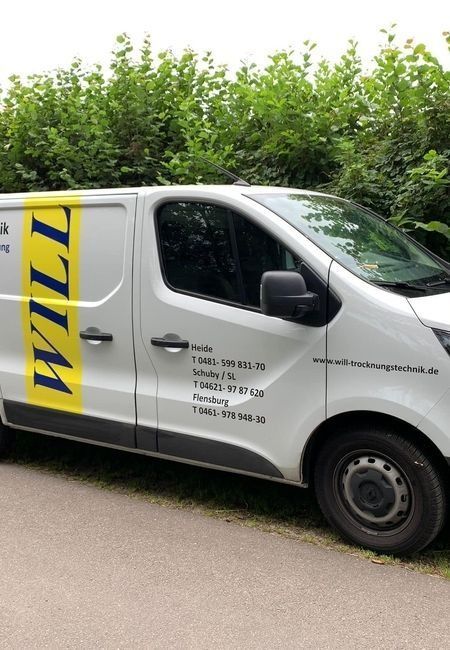 Weißer Lieferwagen mit gelbem Logo parkt neben einer Hecke an einer Straße