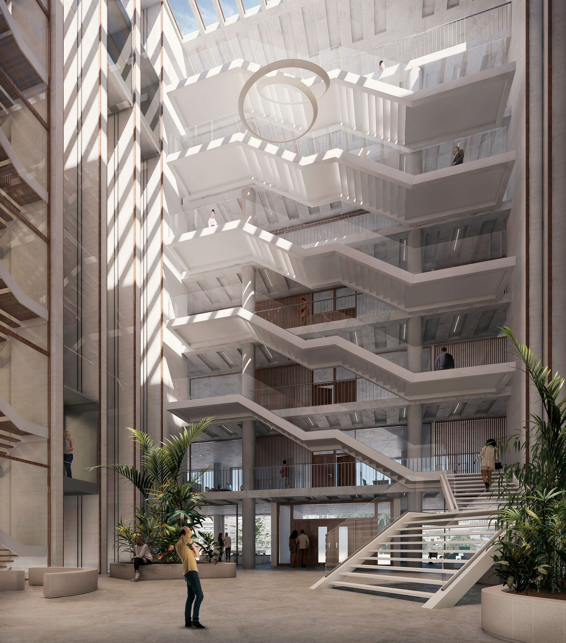 Vista interior del atrio de un edificio moderno con varios niveles, escaleras y luz natural.