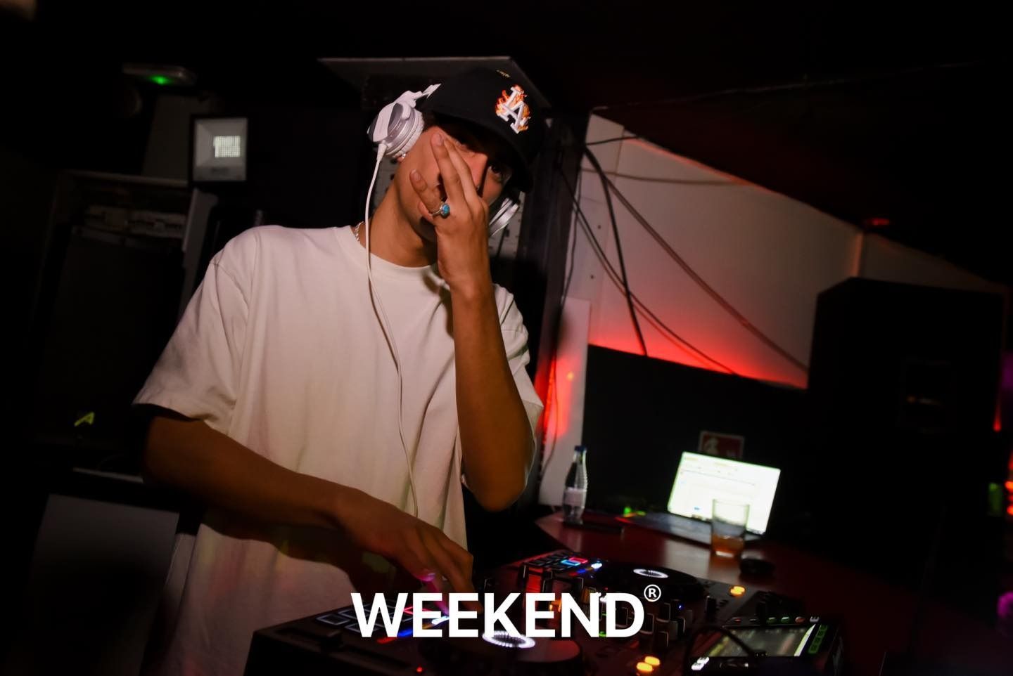 Un hombre que usa auriculares está reproduciendo música en una habitación oscura.