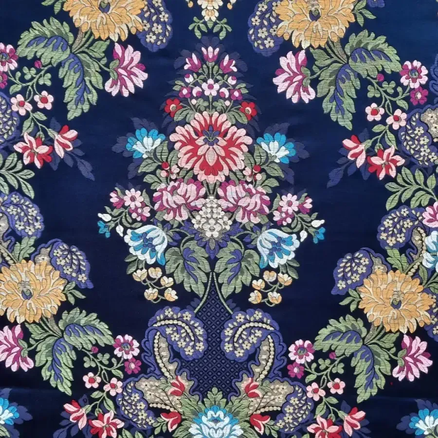 Tela azul oscuro con estampado floral adornado en amarillo, rosa, rojo y azul.