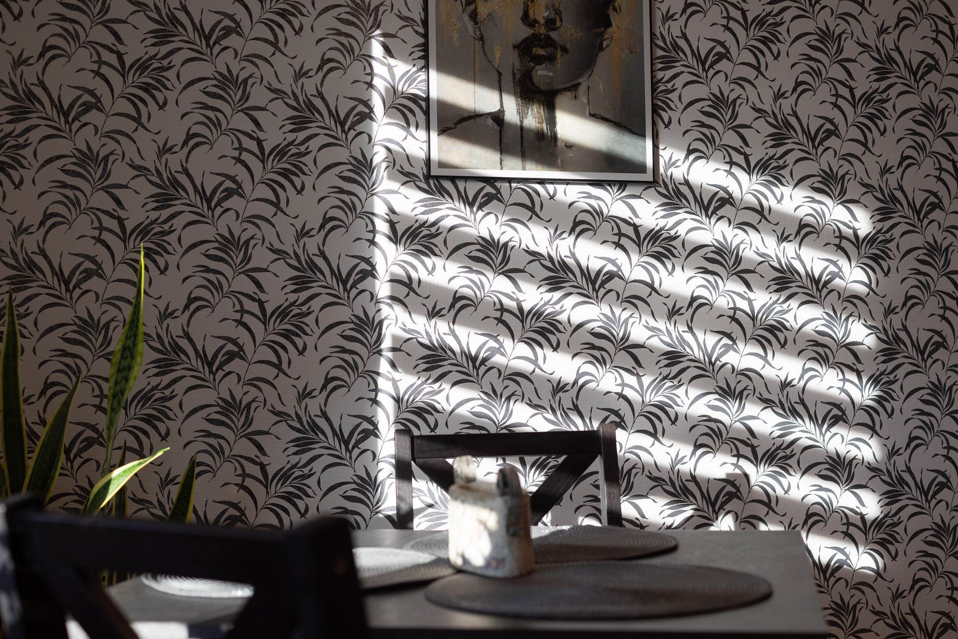 Ein Esszimmer mit einem Tisch und Stühlen und einem Bild an der Wand.