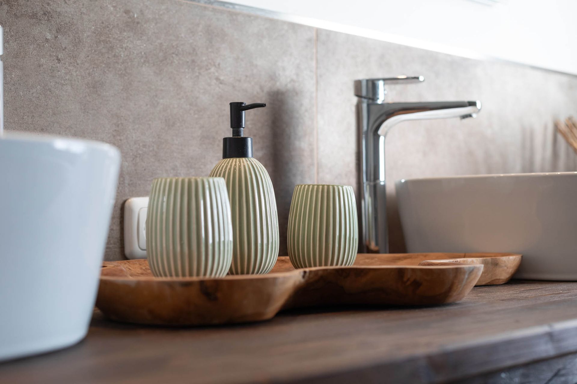 Ein Badezimmer mit zwei Waschbecken, einem Seifenspender und einem Wasserhahn.