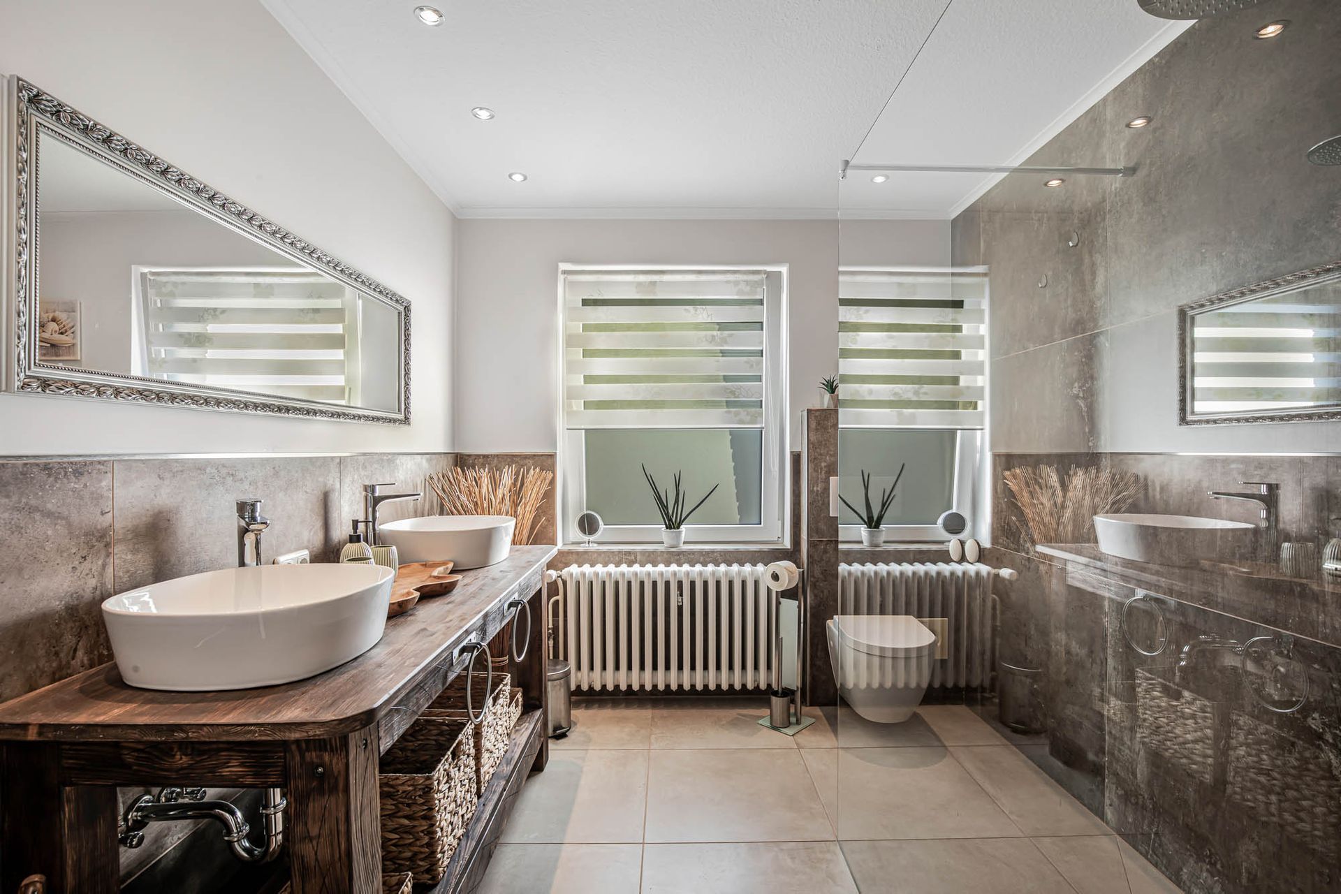 Ein Badezimmer mit zwei Waschbecken, einer Toilette und einem Spiegel.