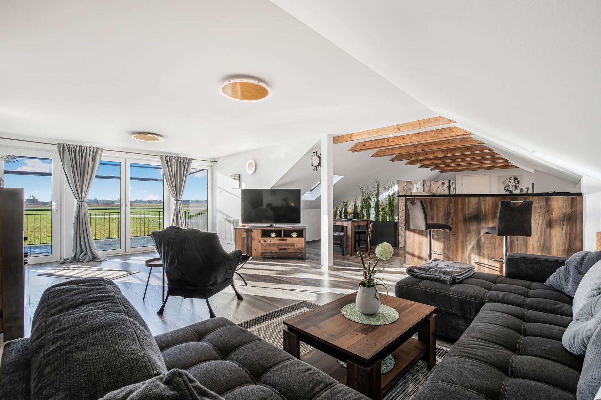 Ein Wohnzimmer mit Couch, Stühlen, Tisch und Fernseher.