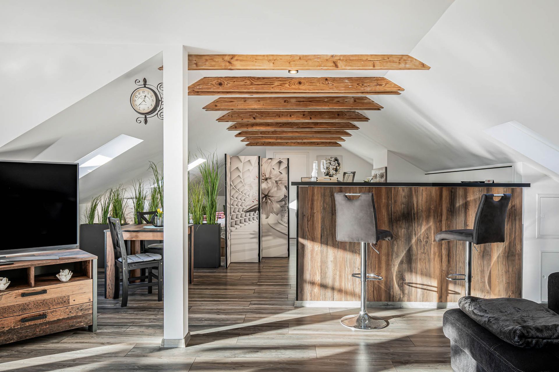 Ein Wohnzimmer mit einer Bar und einer Uhr an der Wand.