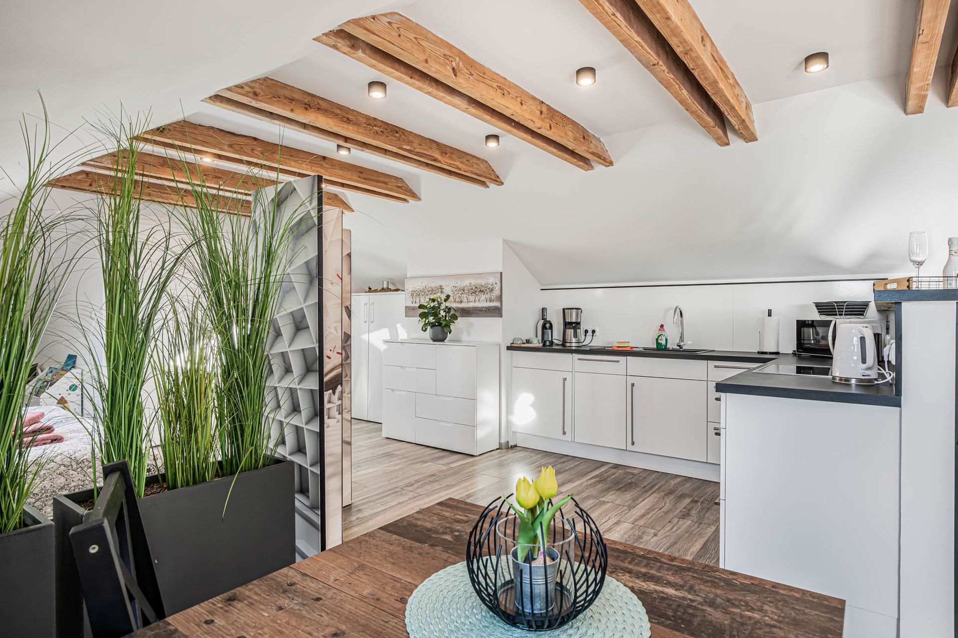 Eine Küche mit einem Holztisch und einer Schale mit Blumen darauf.