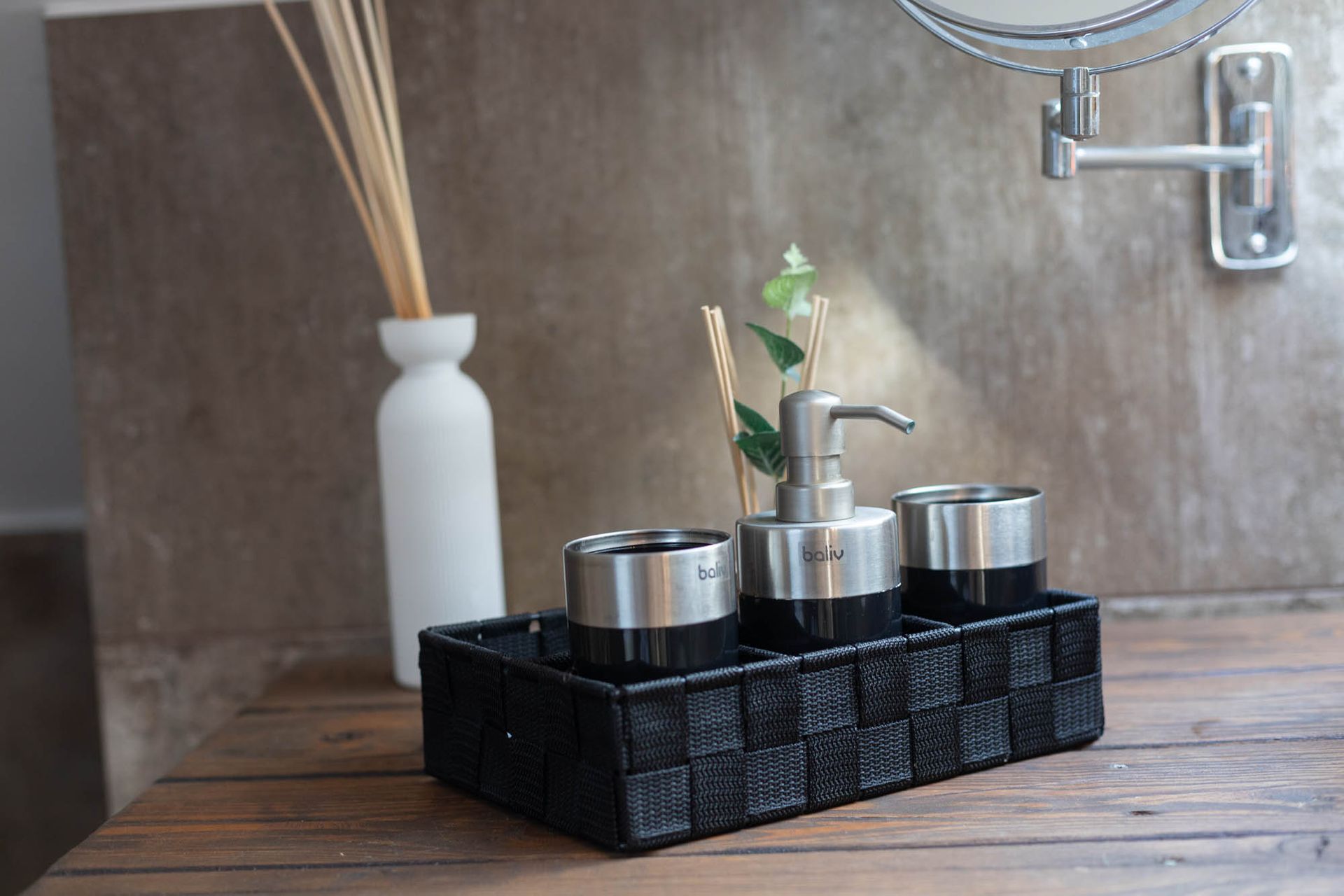 Eine Badezimmerablage mit Seifenspender, Zahnbürstenhalter und Spiegel.