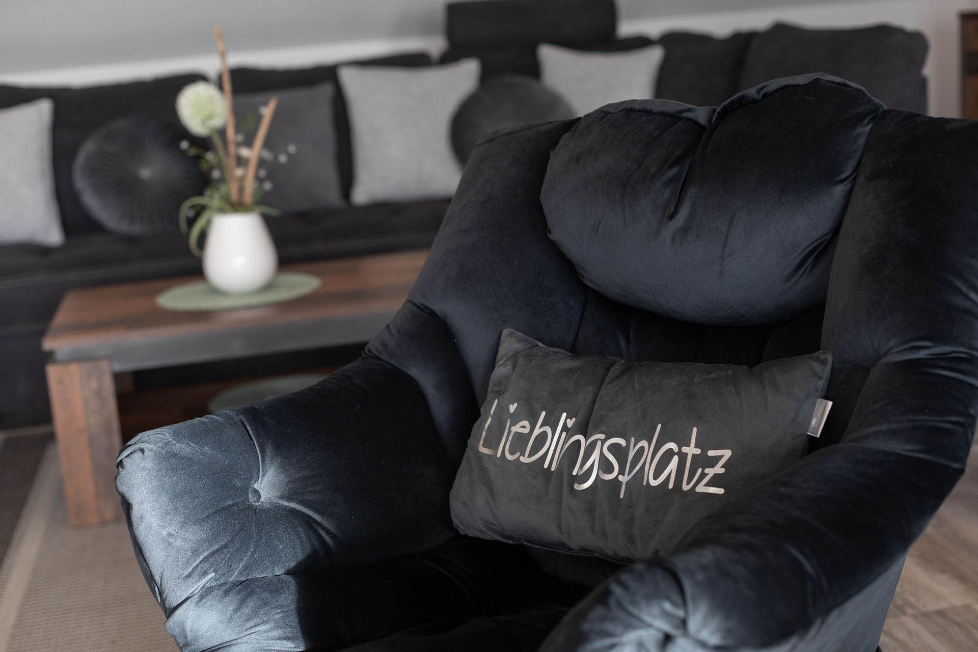 Ein schwarzer Stuhl mit einem Kissen darauf in einem Wohnzimmer.