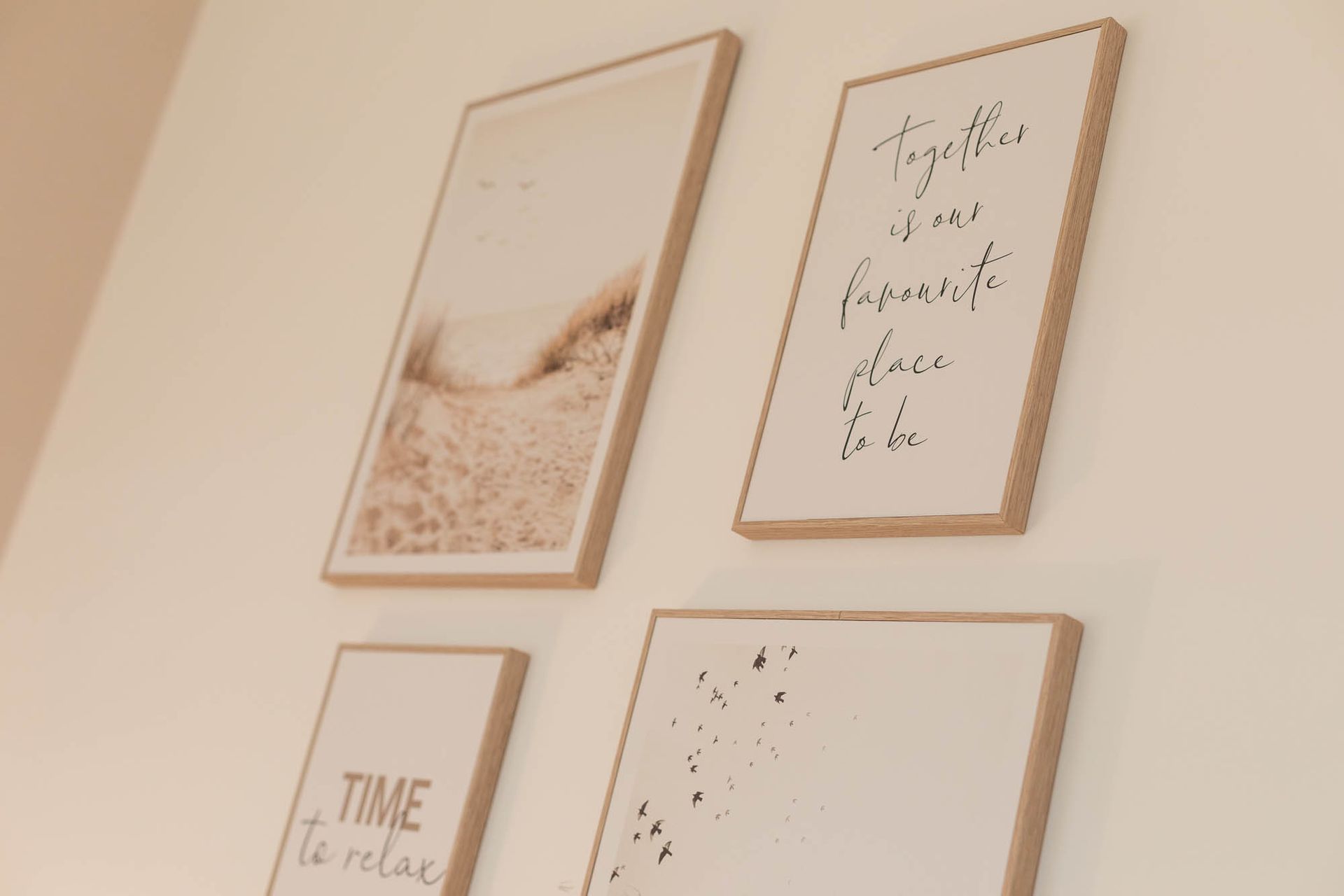 Vier gerahmte Bilder an einer Wand, eines davon mit der Aufschrift „Zeit zum Entspannen“