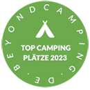 Ein grüner Kreis mit der Aufschrift „Top-Campingplätze 2023“ darauf.