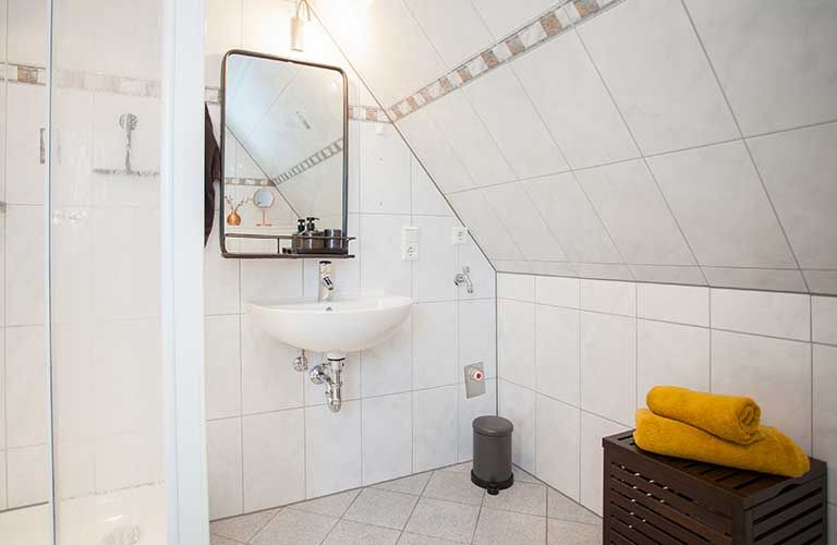 Ein Badezimmer mit Waschbecken, Spiegel und Dusche.