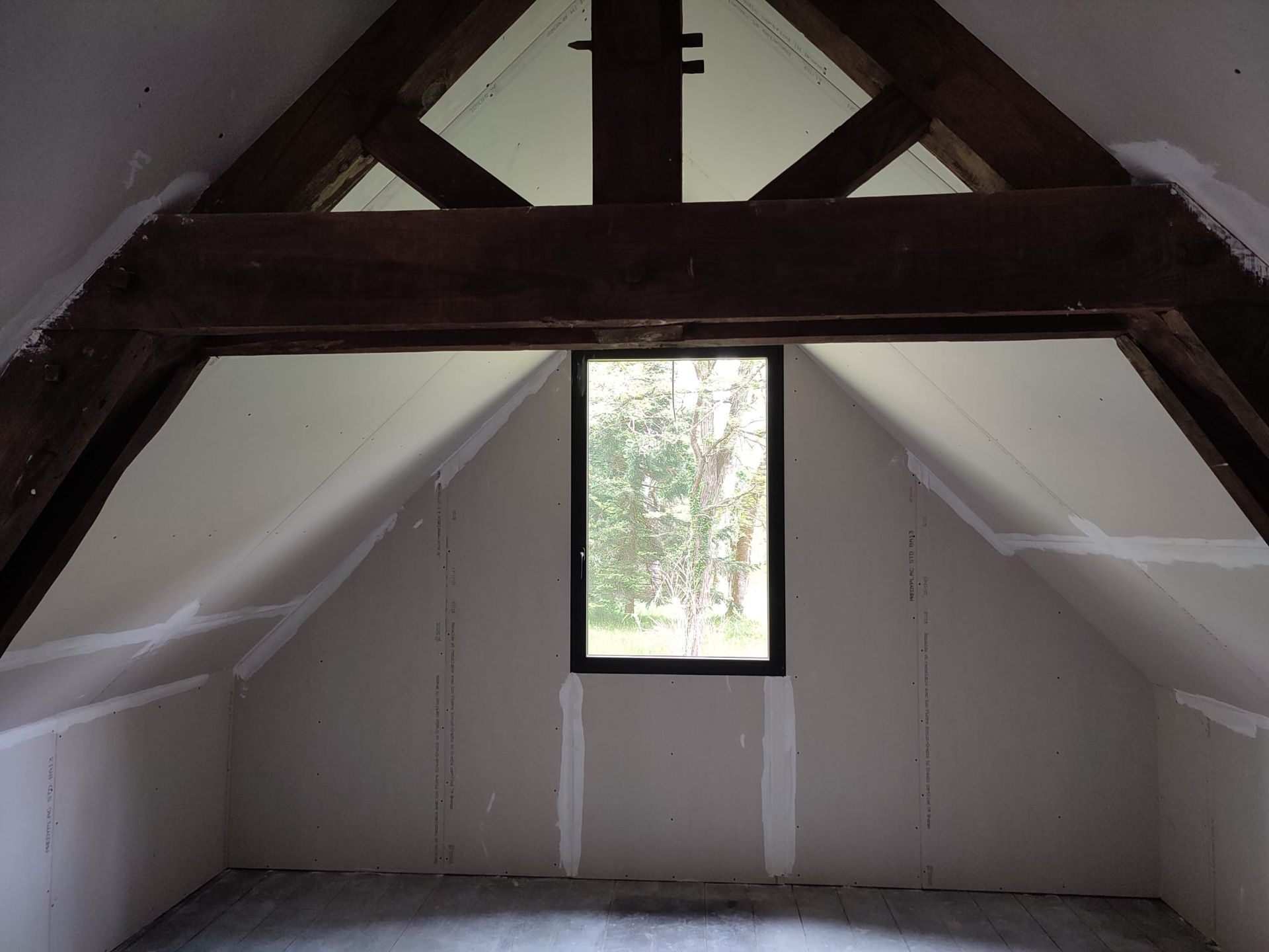 Une pièce avec une poutre sous les combles