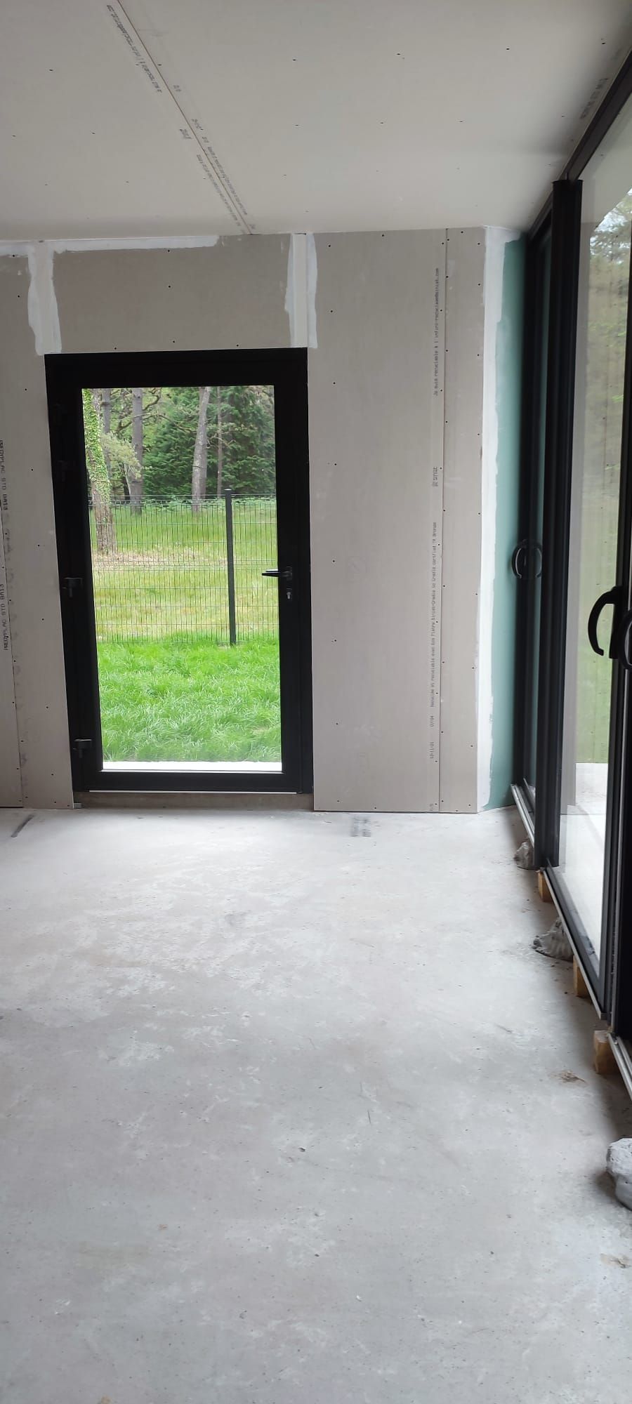 Une pièce avec une baie vitrée au fond