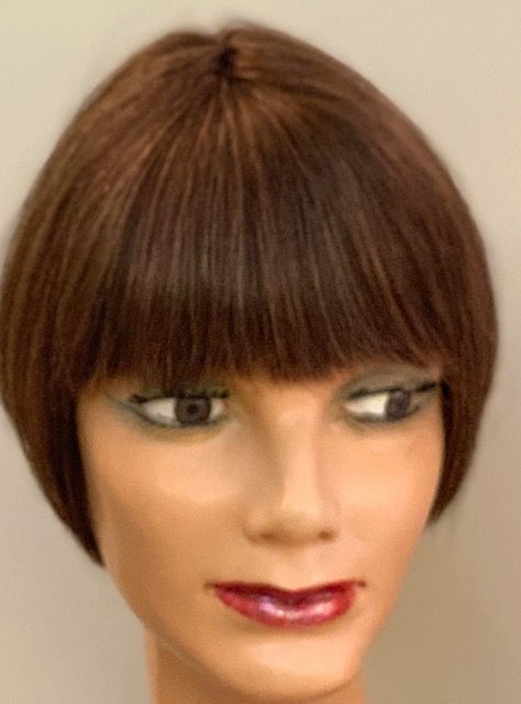 Un primer plano de una cabeza de maniquí con una peluca.