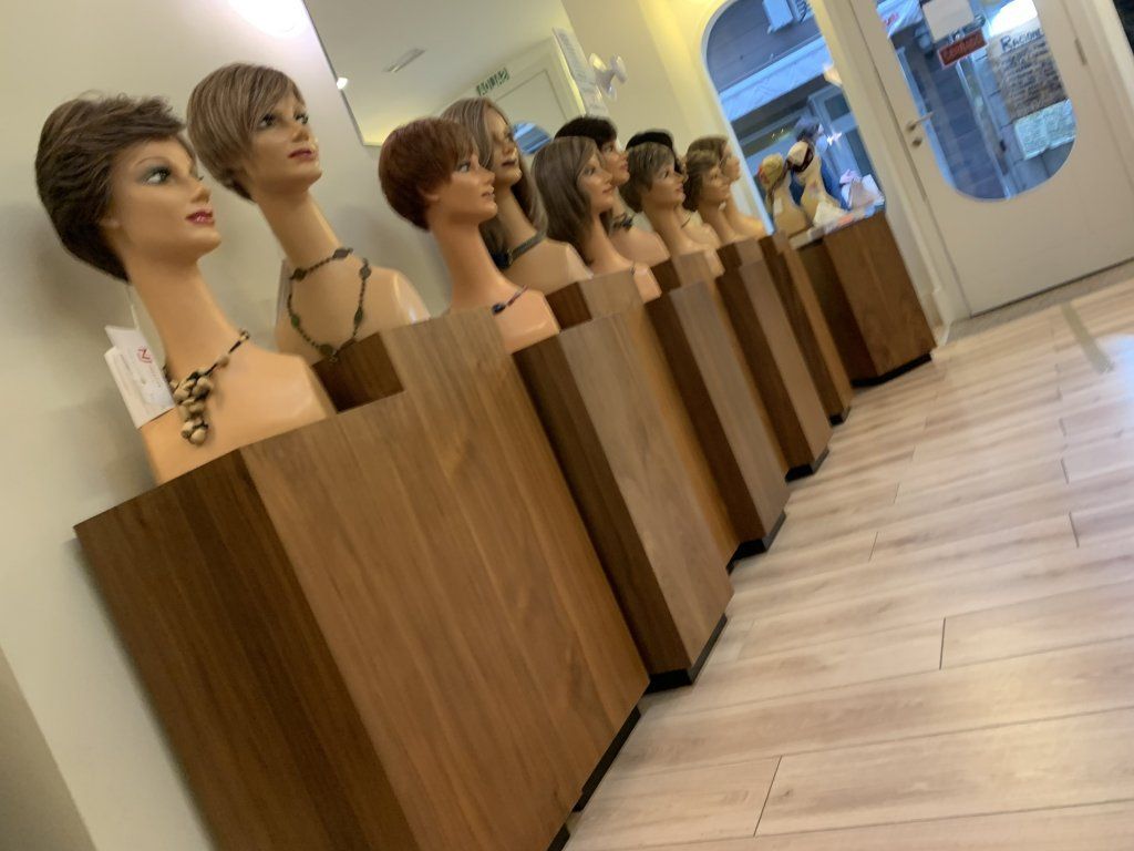 Una fila de cabezas de maniquí sentadas sobre soportes de madera en una habitación.