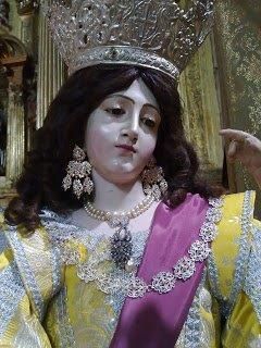 Una estatua de una mujer que lleva una corona y pendientes.