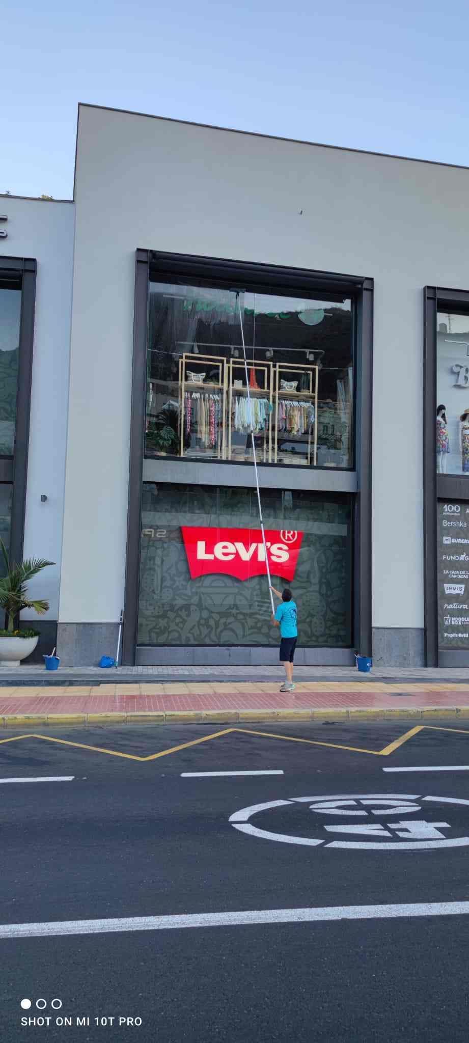 Una mujer está parada frente a una tienda Levi's.