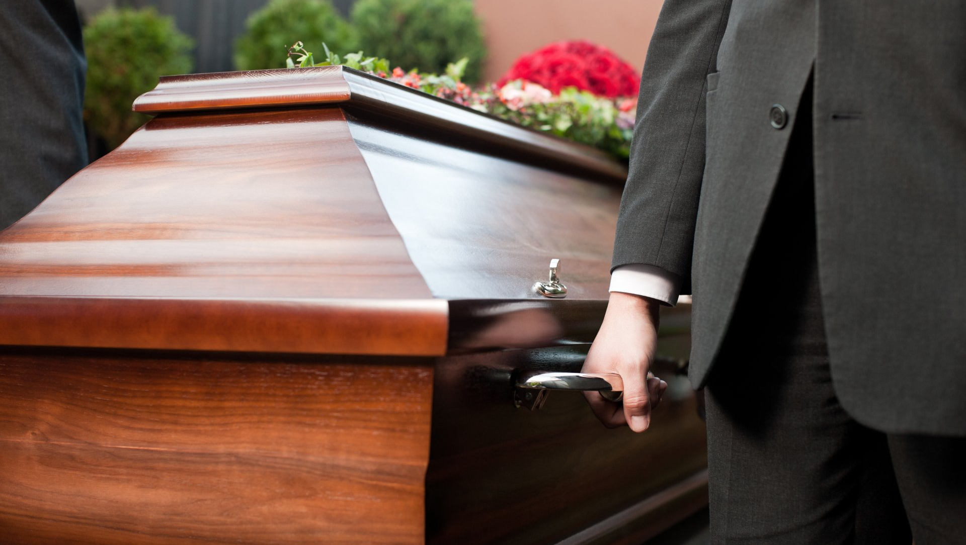 Cercueil en chêne marron foncé avec gerbe sur son couvercle