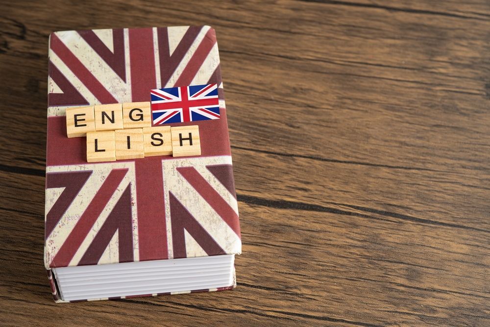 Un pequeño libro con una portada de la bandera británica y fichas con letras que forman la palabra