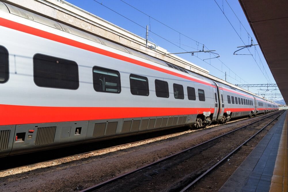 Un tren rojo y blanco está parado en las vías.