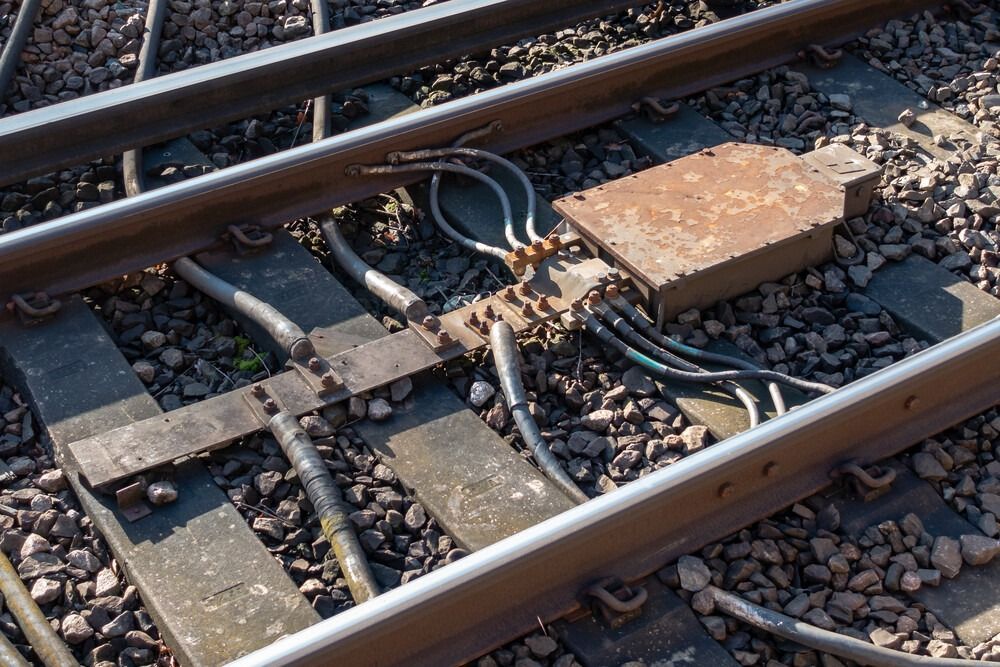 Un primer plano de una vía de tren con muchos cables en ella.