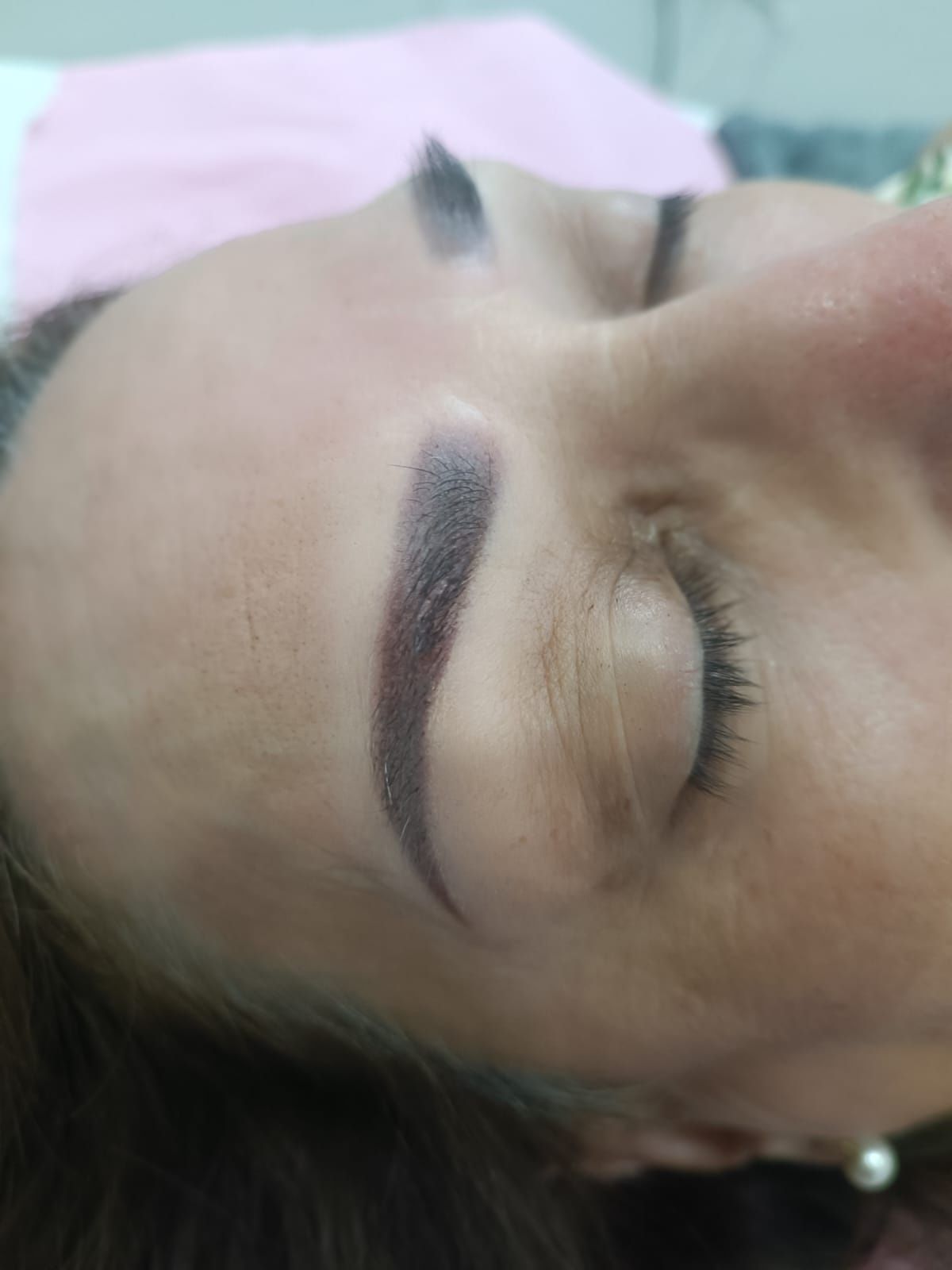 Primer plano del rostro de una persona con una ceja oscura y ojos cerrados.