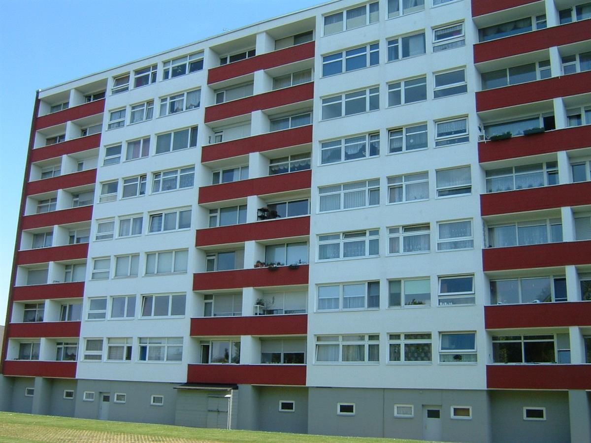 Ein hohes Gebäude mit vielen Fenstern und Balkonen