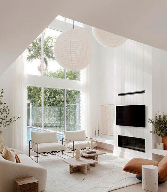 Una sala de estar con chimenea, sofá, sillas y televisión.