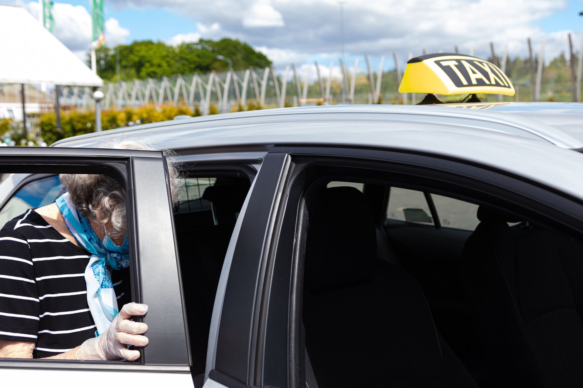Dame âgée qui monte en voiture