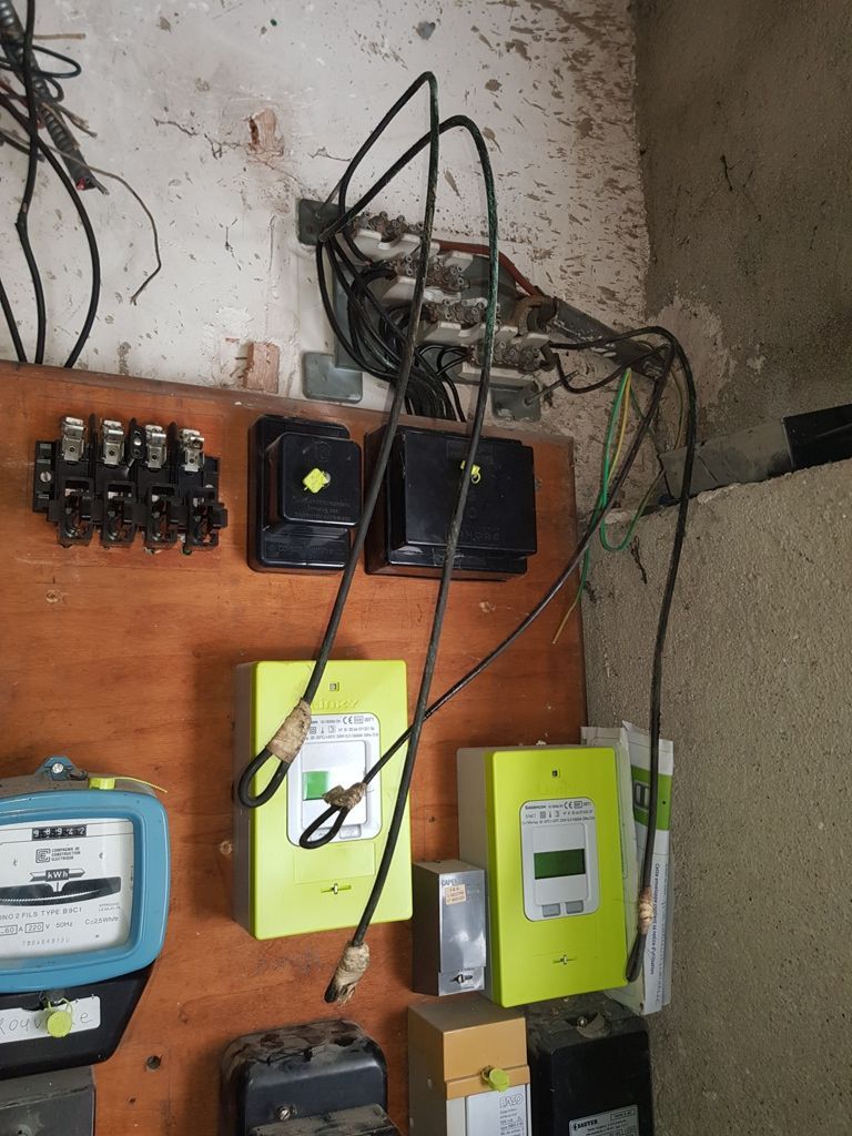 2 boîtiers verts accrochés sur une planche en bois qui est elle-même accrochée sur un mur