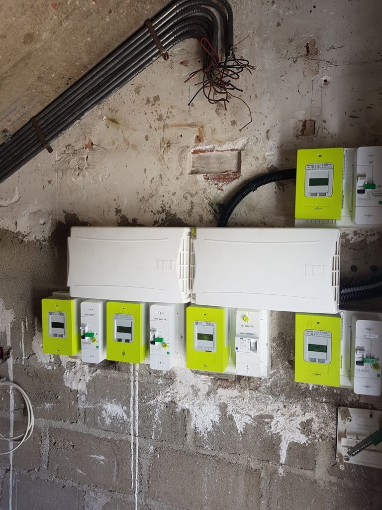 5 boîtiers verts accrochés sur un mur