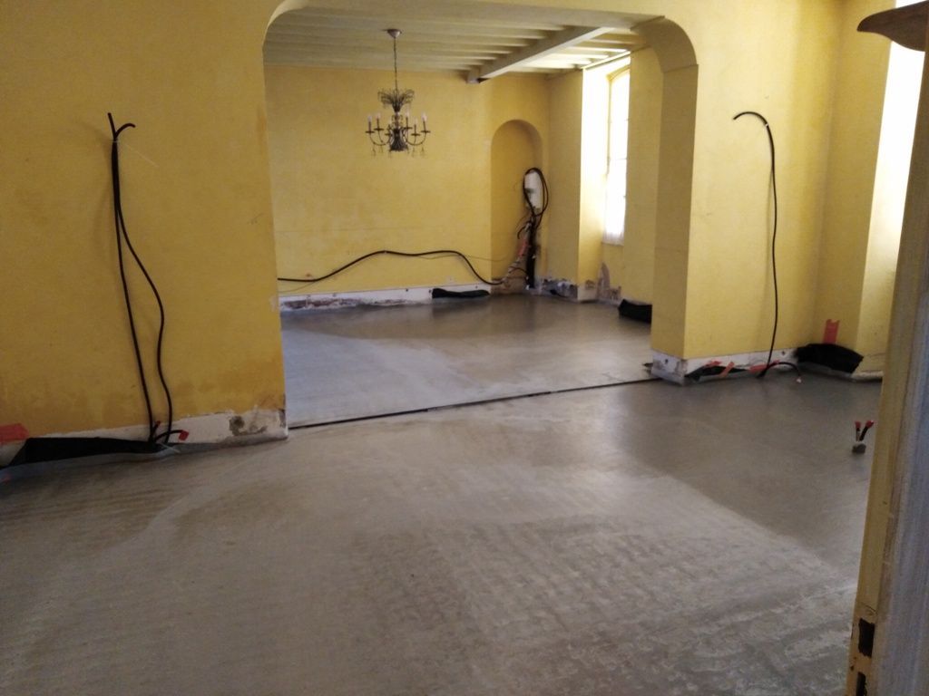 Une pièce peinte en jaune avec une ouverture en arc donnant sur une autre pièce jaune