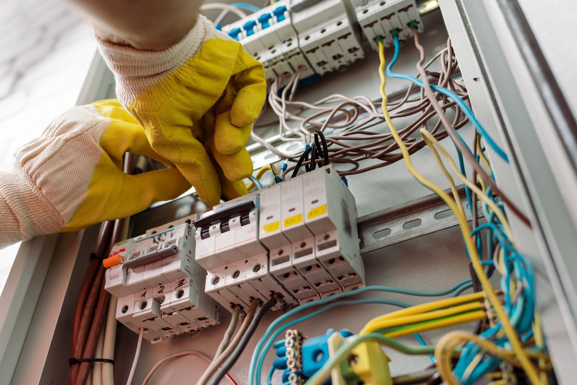 Un électricien effectue le câblage d'un tableau électrique.