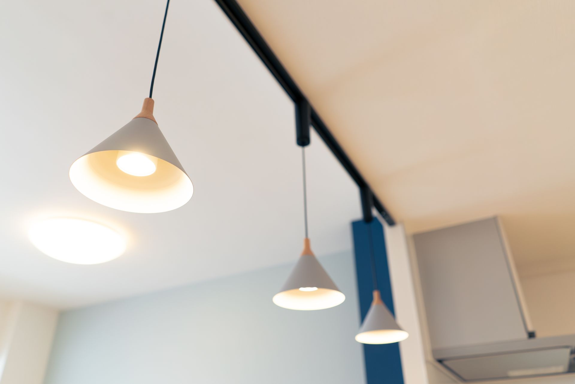 Trois suspensions blanches ornent le plafond d'une pièce moderne et lumineuse.