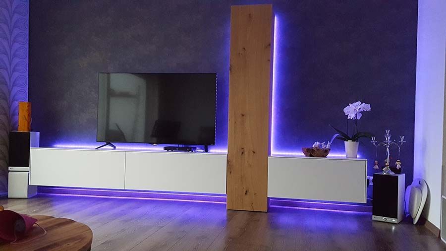 Ein Wohnzimmer mit violetten Lichtern und einem Flachbildfernseher