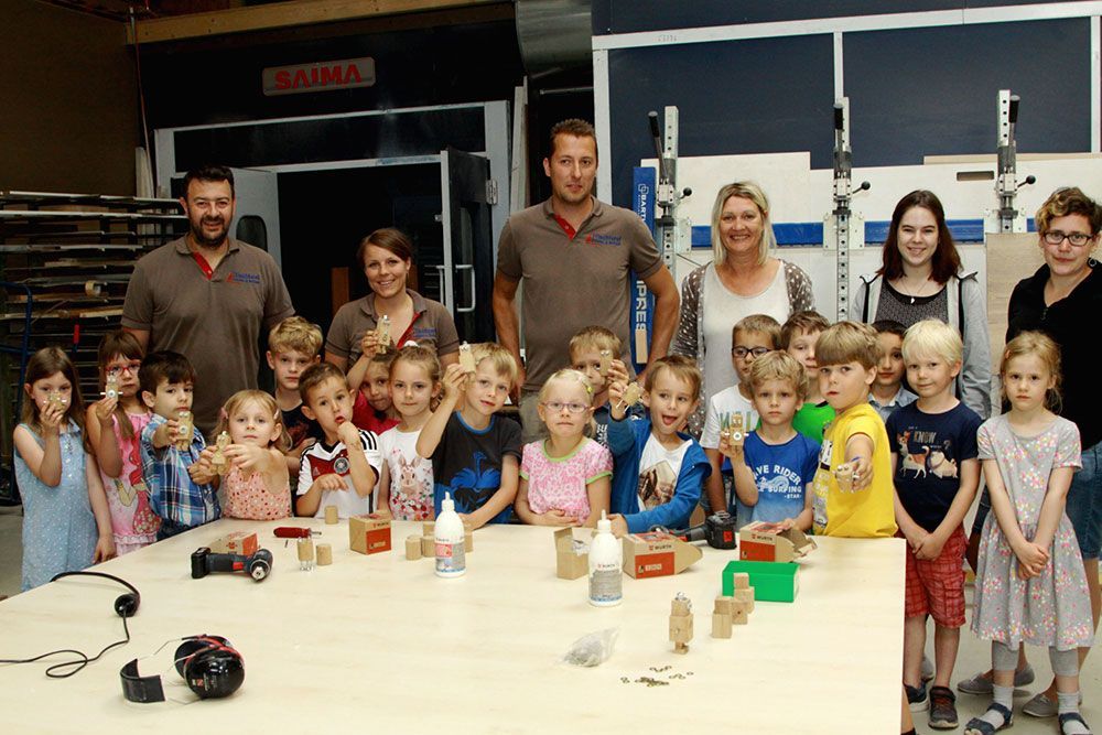 Eine Gruppe von Kindern posiert für ein Foto vor einem Schild mit der Aufschrift „Sigma“