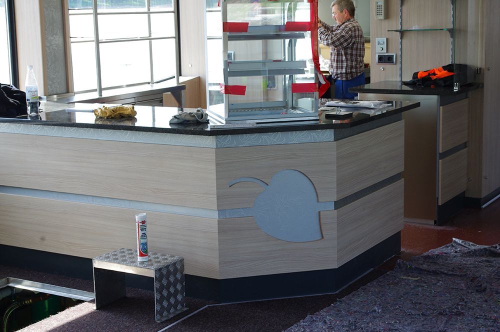 Ein Mann steht hinter einer Theke mit einem Schild darauf, auf dem