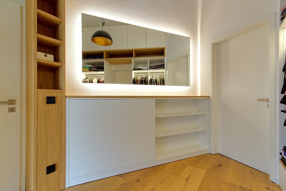 Ein Schrank mit einem großen Spiegel an der Wand