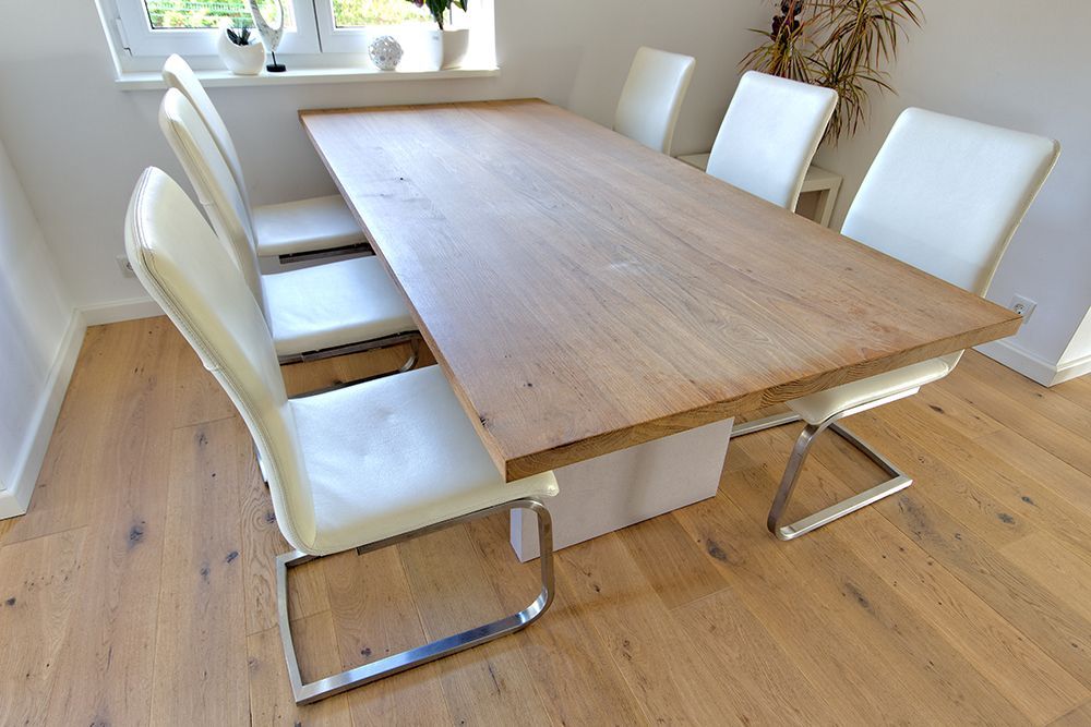 Ein Holztisch mit weißen Stühlen in einem Esszimmer