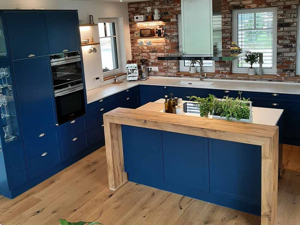 Eine Küche mit blauen Schränken und einer Holzinsel
