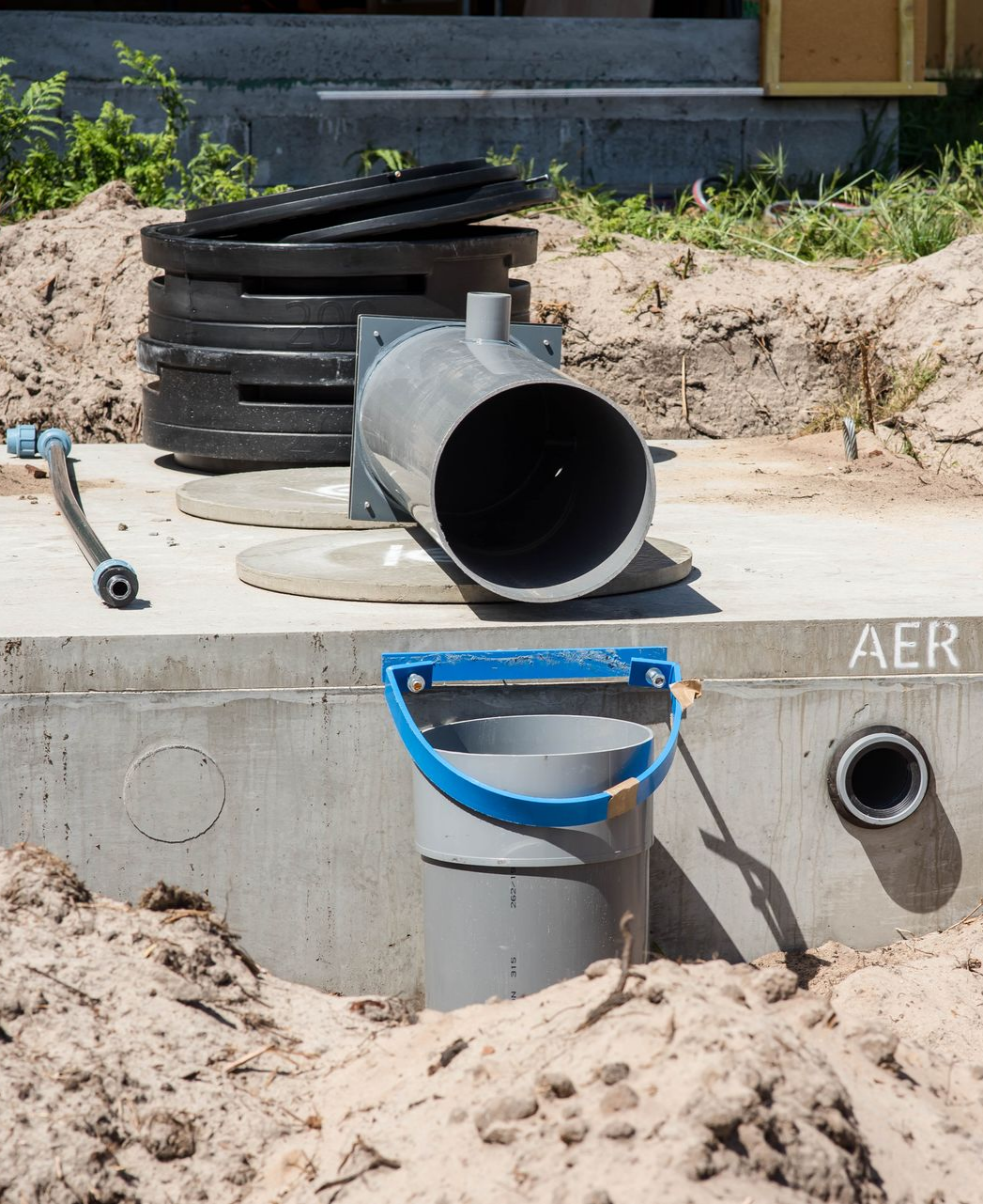 Chantier : fosse septique en béton avec tuyau ouvert.