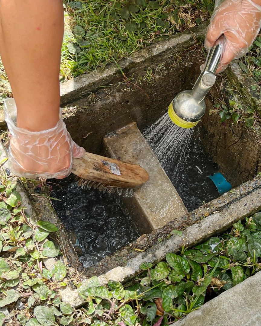 Une personne nettoie un bac à graisse.