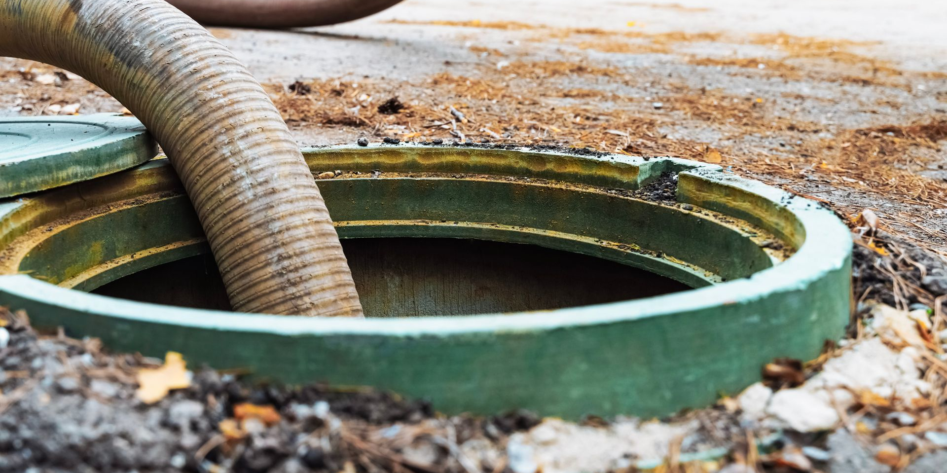 Un tuyau inséré dans une bouche de fosse septique.