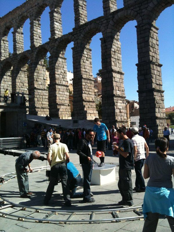 Un equipo de filmación trabaja frente a un antiguo acueducto de piedra en Segovia, España.