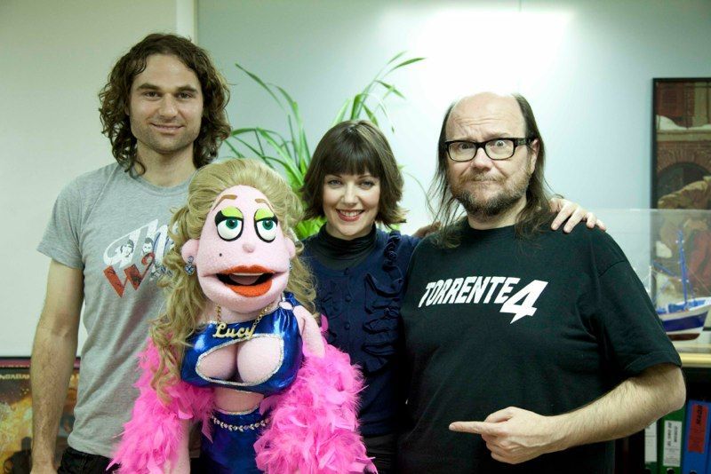 Un grupo posa con una marioneta. Una mujer se encuentra entre dos