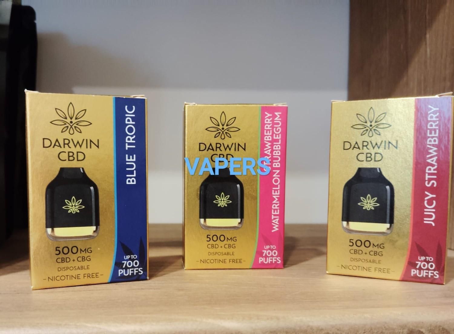 Tres cajas de dispositivos de vapeo desechables Darwin CBD en sabores Blue Tropic, Watermelon Bubblegum y Juicy Strawberry.